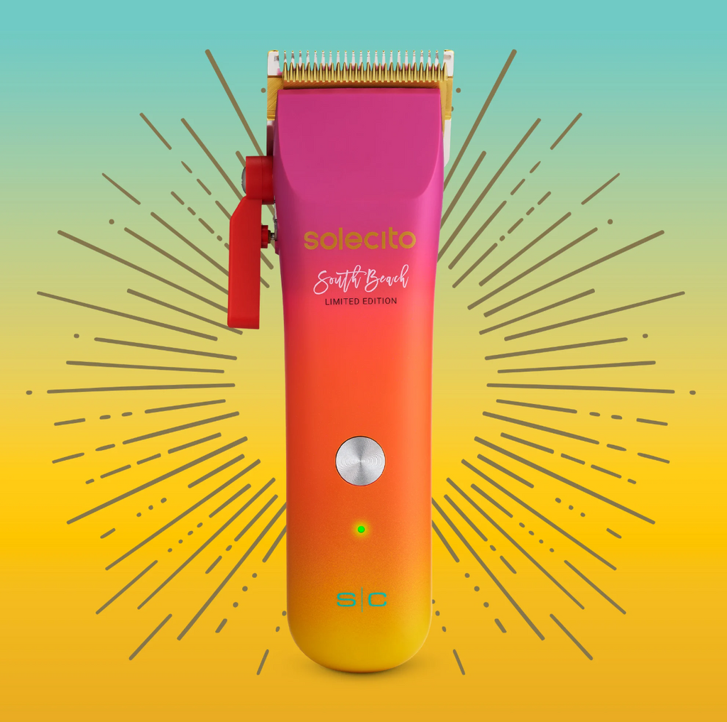 Professional hair clipper with purple head and orange-to-yellow gradient body, power indicator light