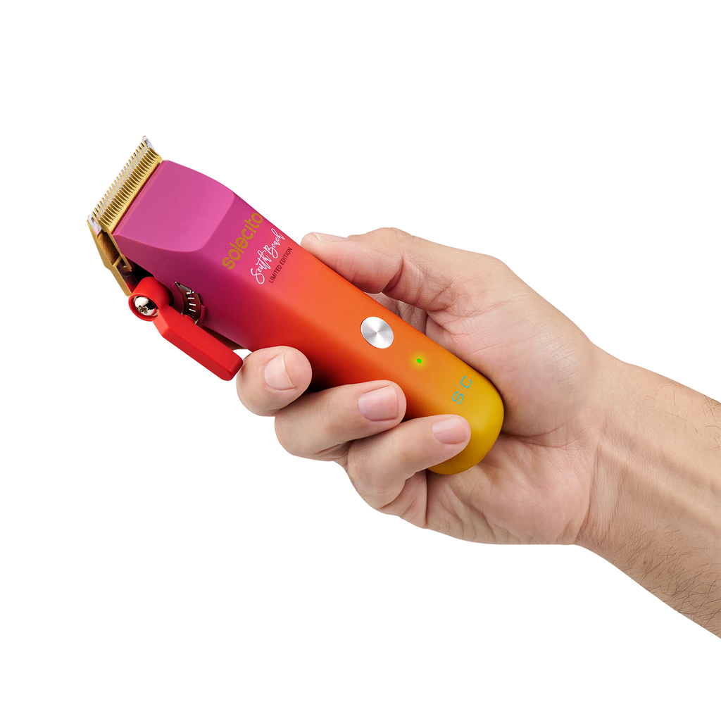 Solecito cordless clipper held in hand, gold trimmer blade, magenta-orange gradient body